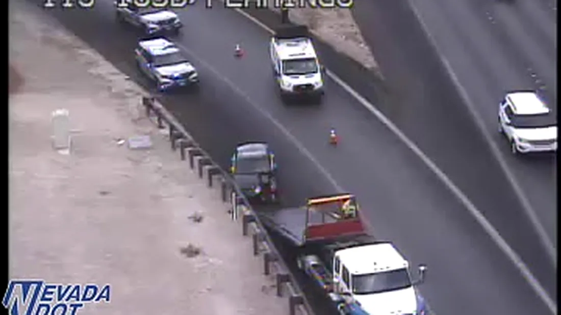 Crash on I-15 southbound at Flamingo Road, Las Vegas, with police on scene and a wrecked car being loaded onto a tow truck