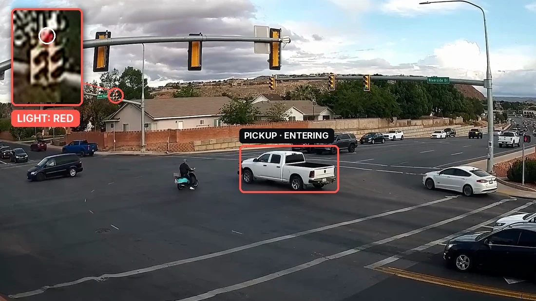 Real crash frame at Riverside Dr and River Rd with the pickup’s signal head zoomed in, showing red